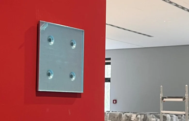 Türschild wird an Wand angebracht