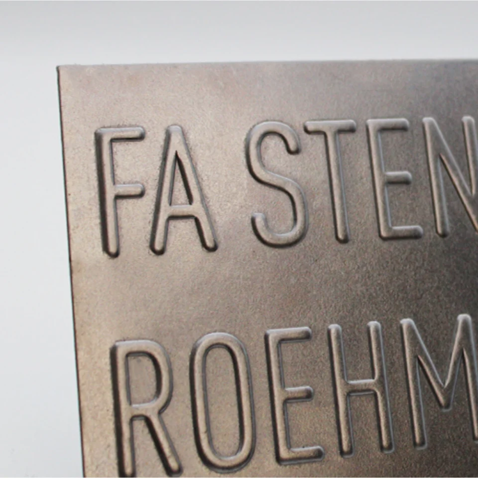 Nahaufnahme eines Metallschilds mit geprägter Beschriftung